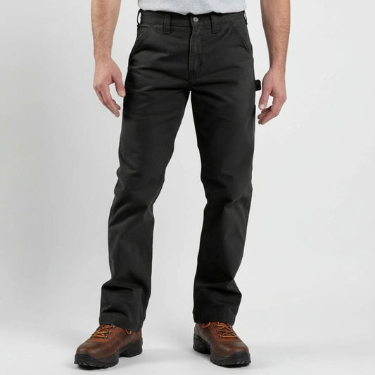 Person wearing black pants and brown work boots on a white background